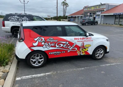 White delivery car with red "The Original Pizza Chief" branding parked outside strip mall in Ventura CA